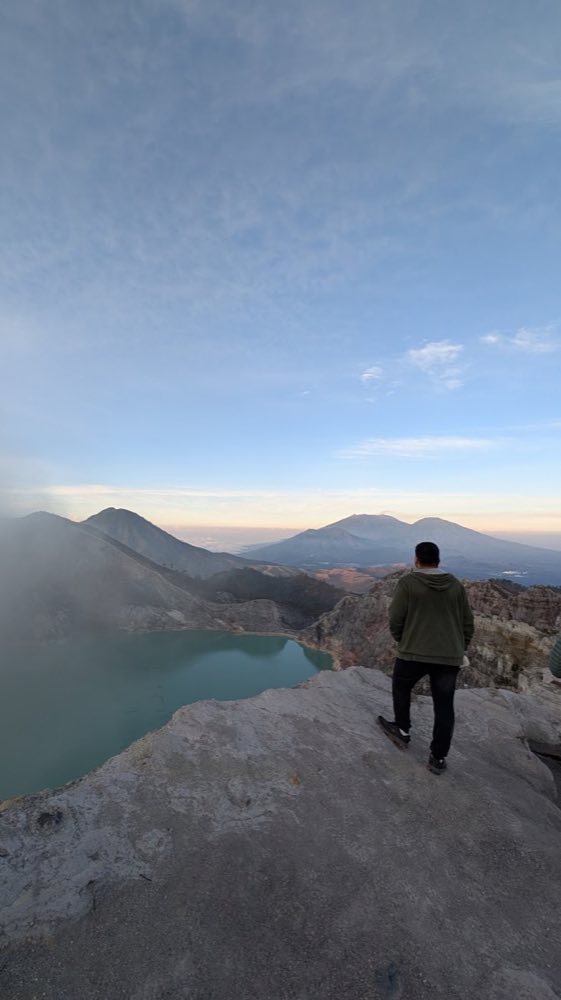 Standing at the rim of Mt. Ijen's turquoise crater lake, Indonesia